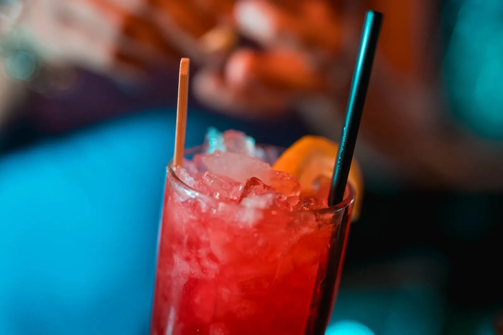 Cóctel rojo con hielo picado, lima y pajita en Margot Bar