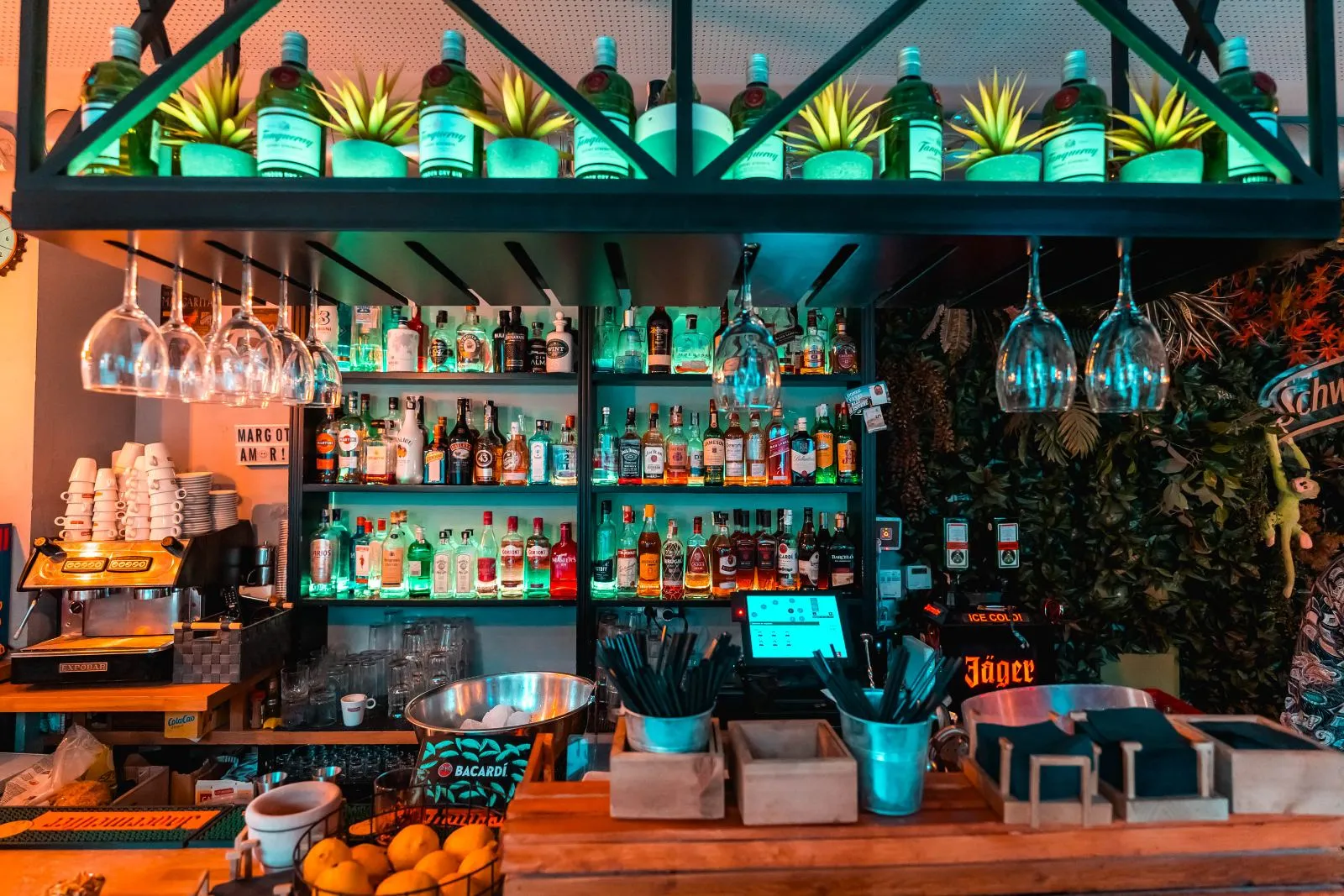 La barra de Margot Bar con botellas iluminadas en verde