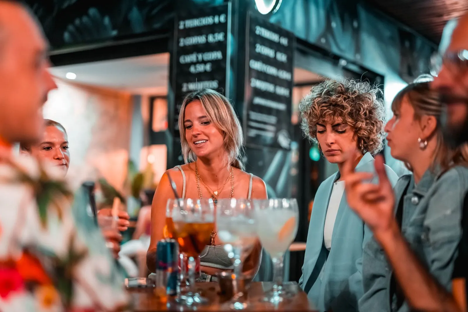 Amigos con gin tonics en copa de balón en la mesa de Margot
