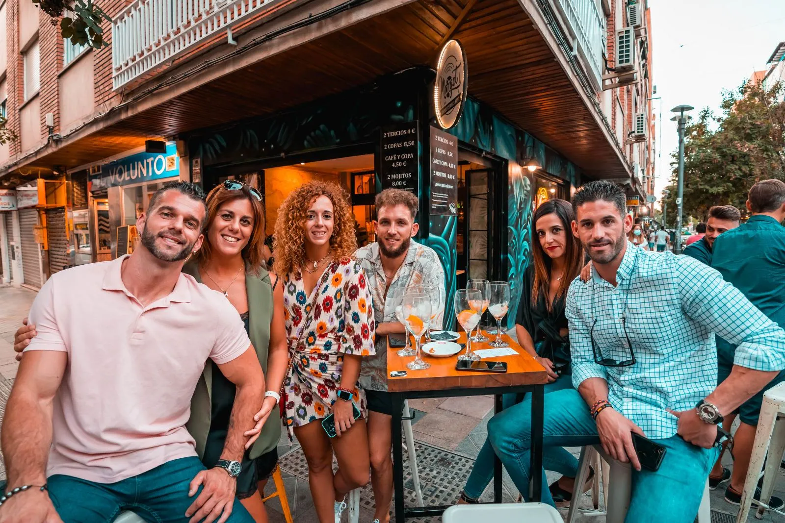 Clientes junto al neón de la fachada de Margot Bar